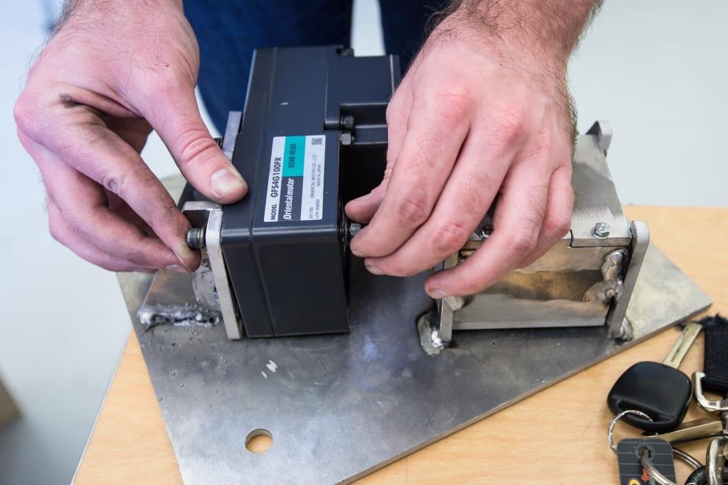 An ASU student attaches the motor assembly on a brake module