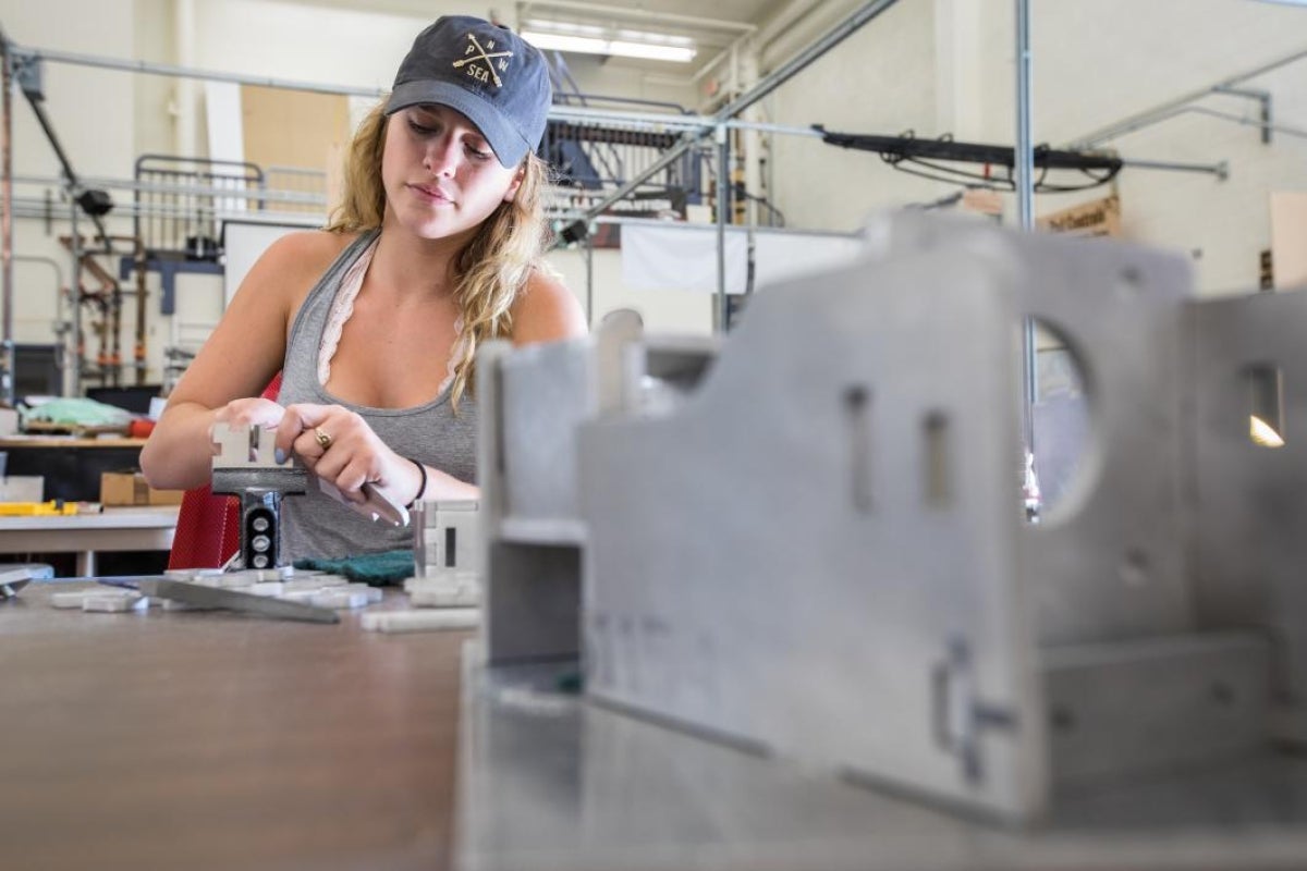 AZLoop team member sands metal components to get them ready for welding