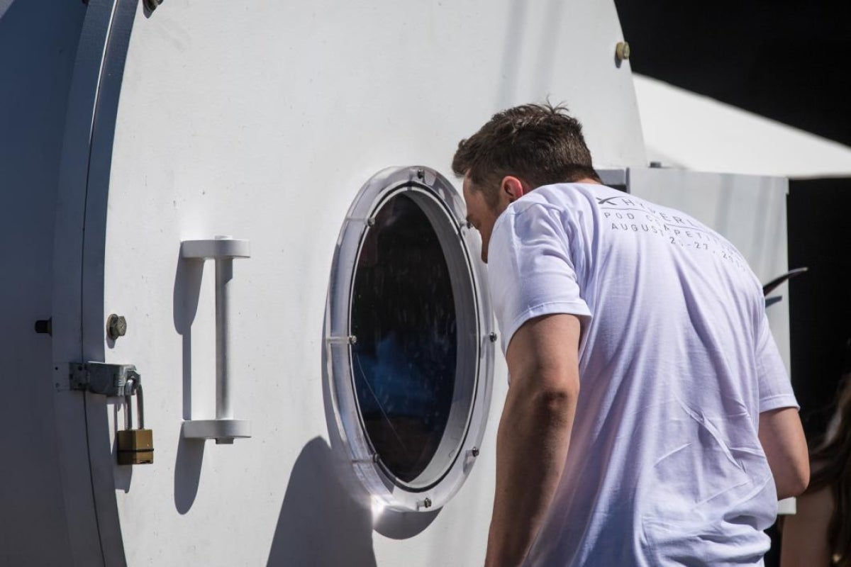 Elon Musk looks into a vacuum chamber