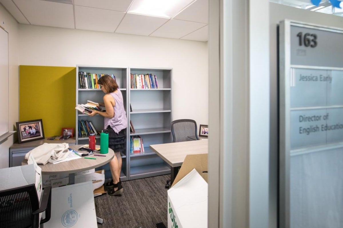 A professor unpacks her books in her new office.