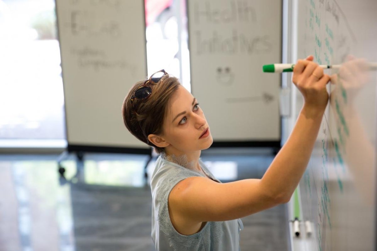 woman writing on a whiteboard