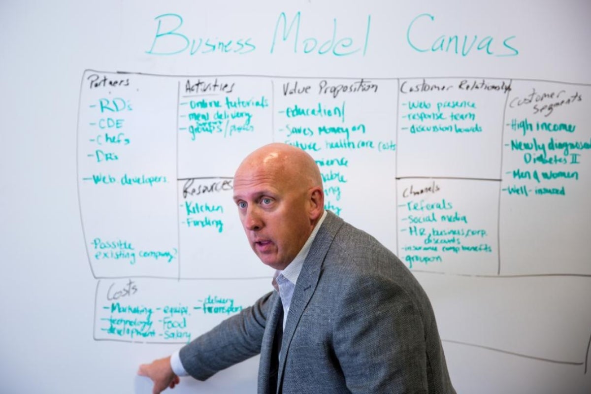 man pointing to whiteboard