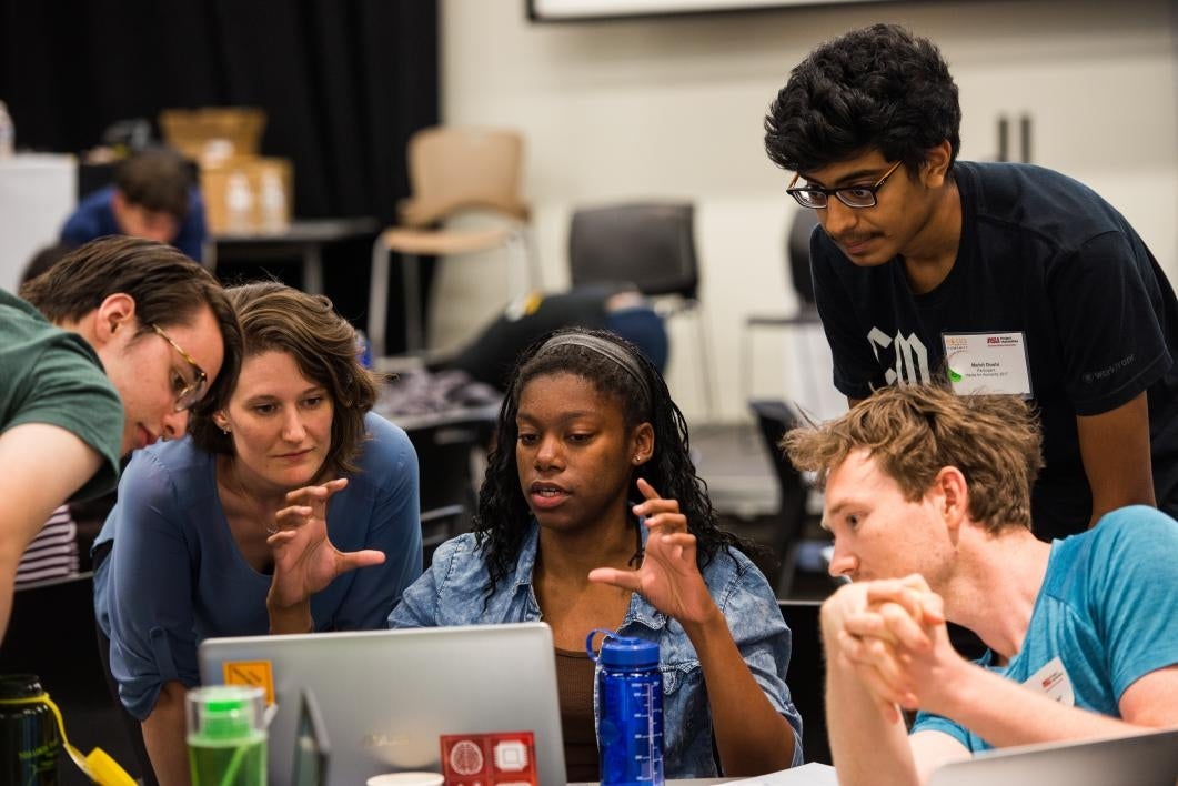 Team gathers around computer