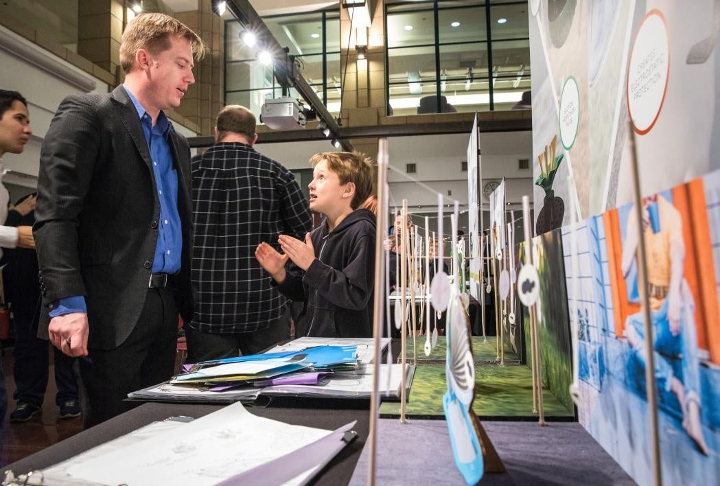 man talking to child at exhibit