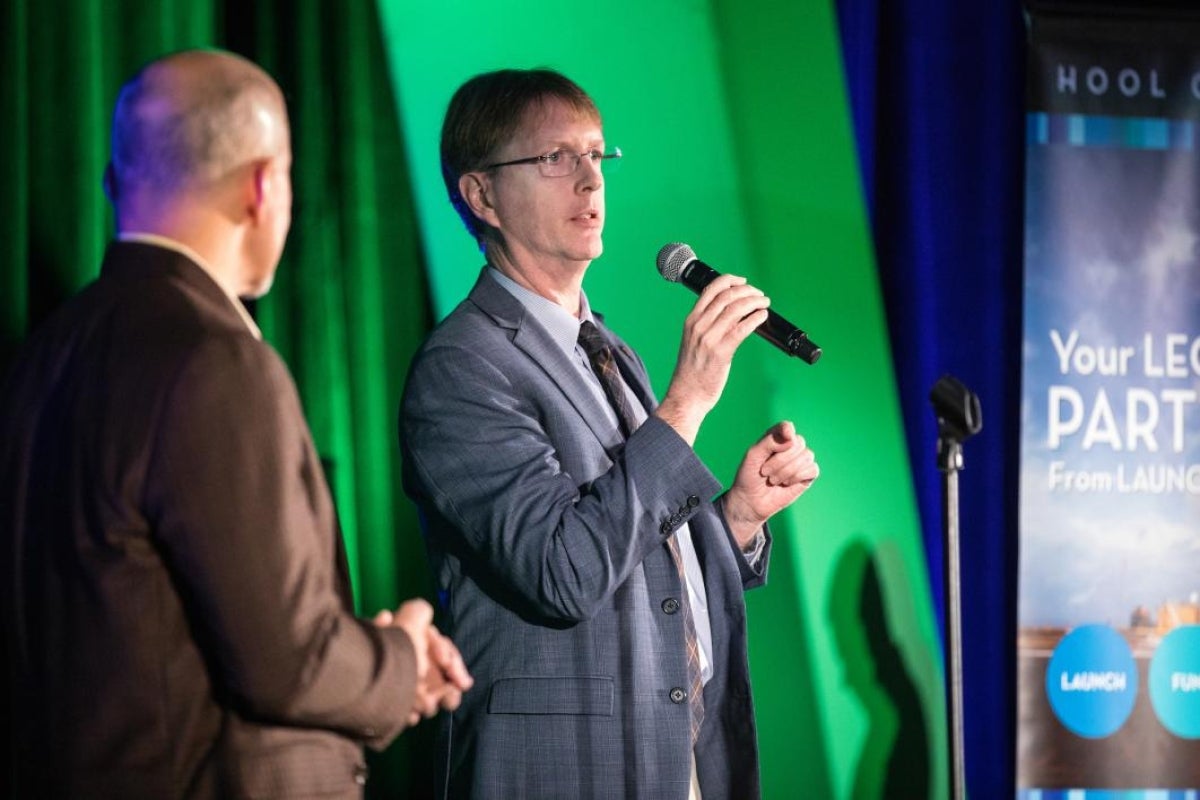 man holding microphone talking to audience