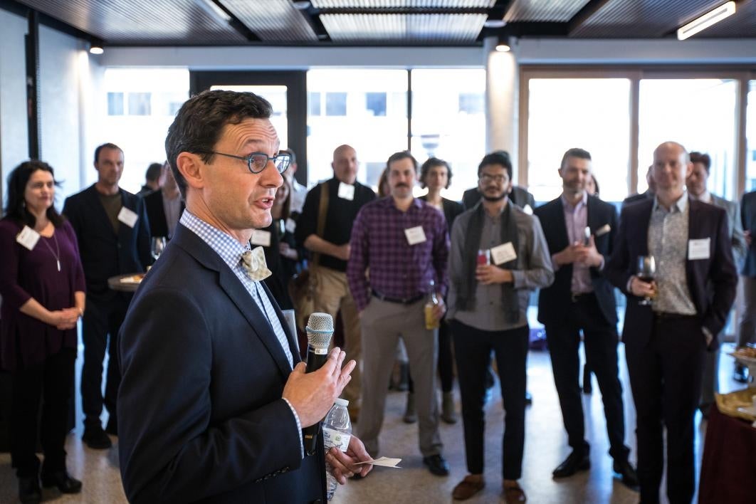 man holding microphone speaking at reception