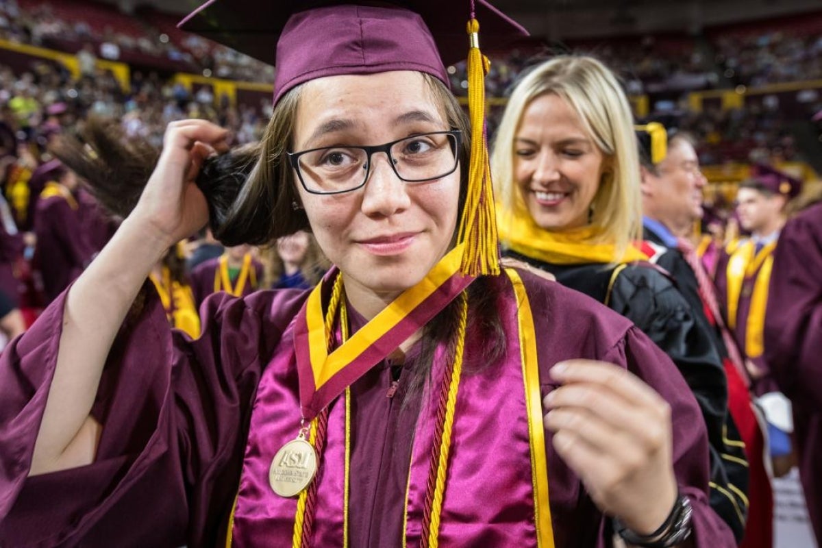 professor putting medal on graduate