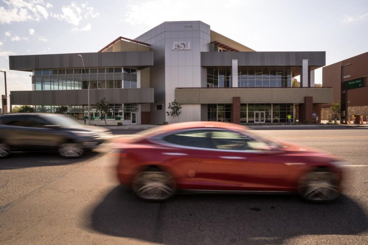 outside view of new Greek Leadership Village with cars driving in front of it