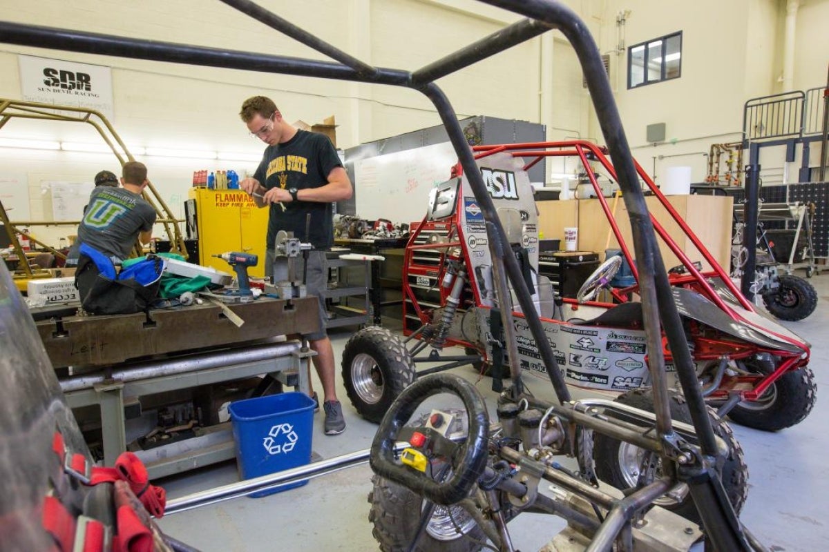 student working on baja car