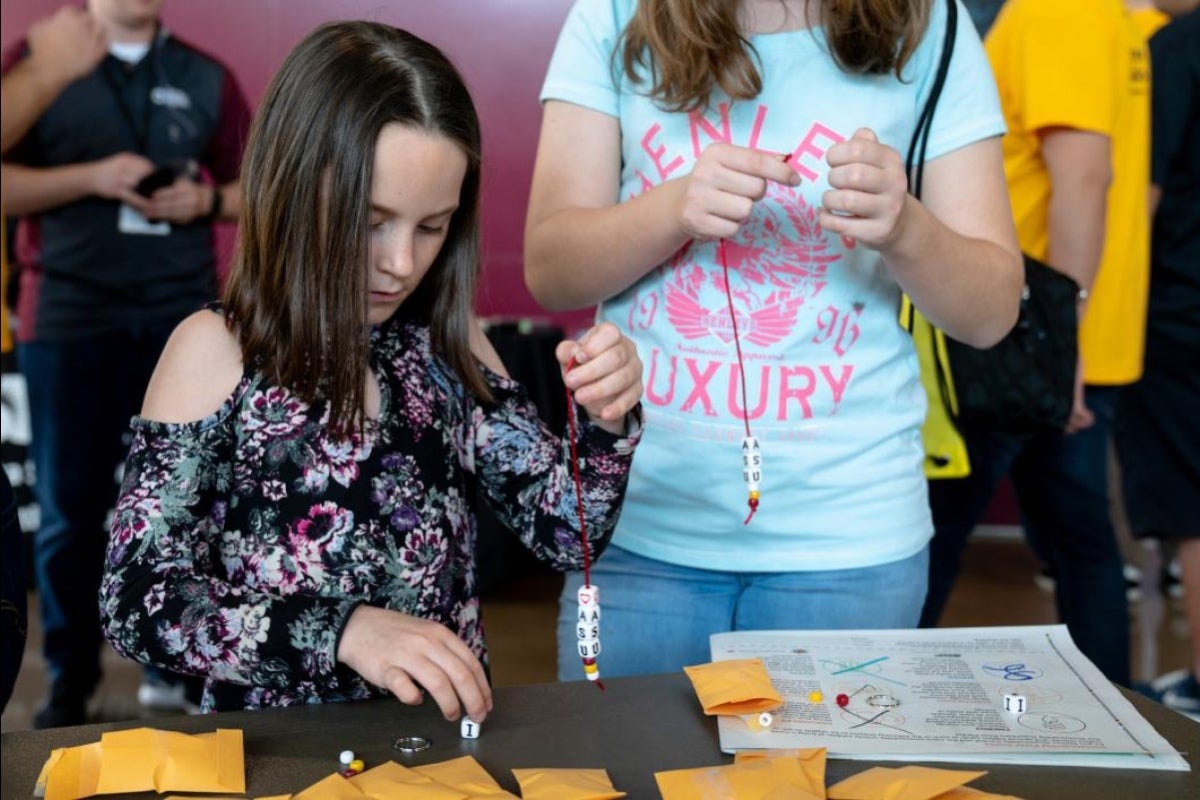 girl making a beaded bracelet