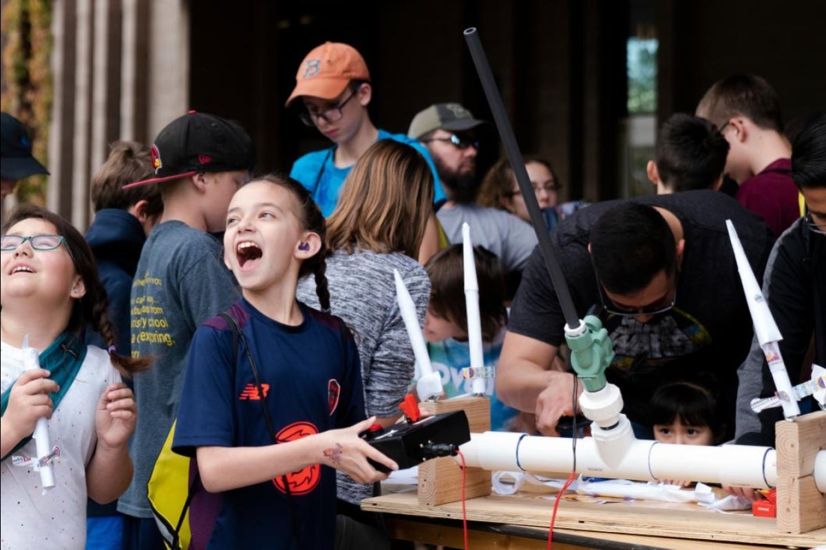 girl smiles after launching a rocket