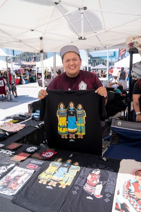 A vendor holds up a shirt at the ASU Pow Wow