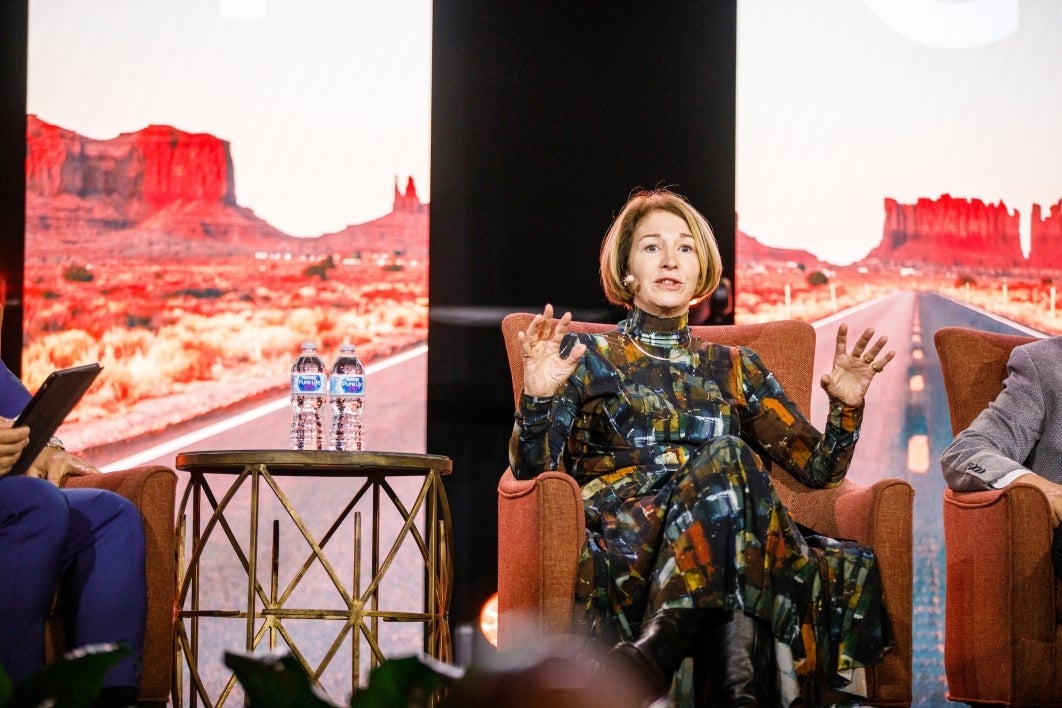 A seated woman speaks on stage during a panel discussion.