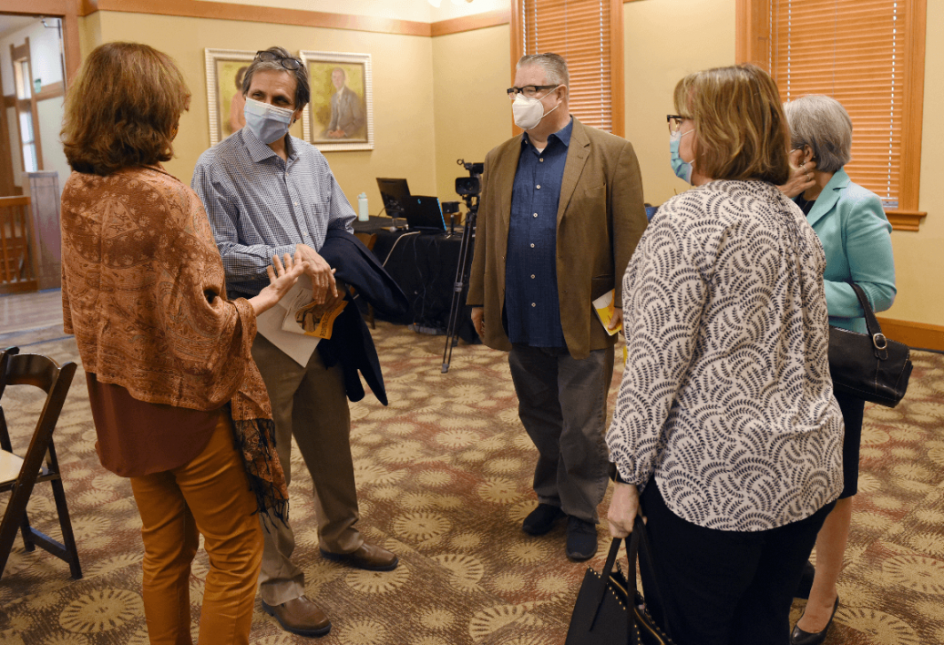 Four of the panelists speak with School of International Letters and Cultures Director Nina Berman after the conference's conclusion. They are standing in a circle in the conference ballroom.