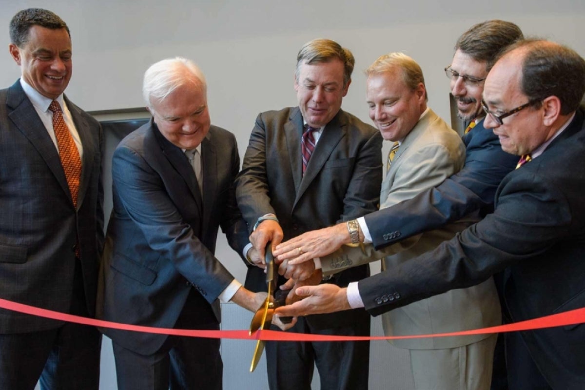 Edd Gibson and others cut a ceremonial ribbon upon completion of College Avenue Commons.