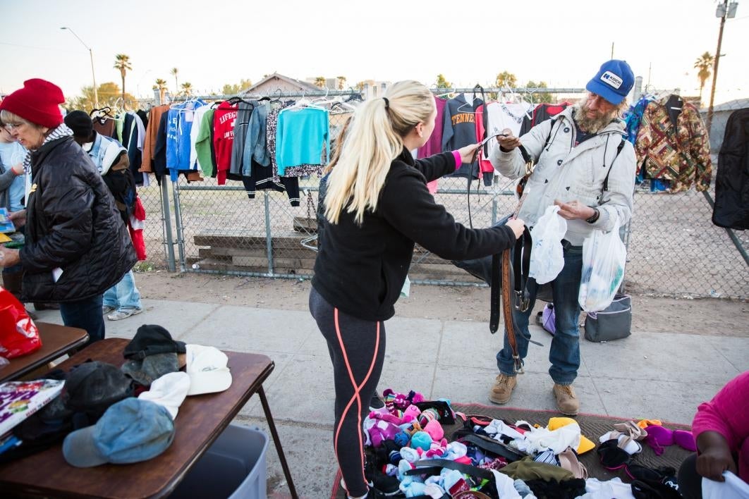 woman helping man pick out a belt