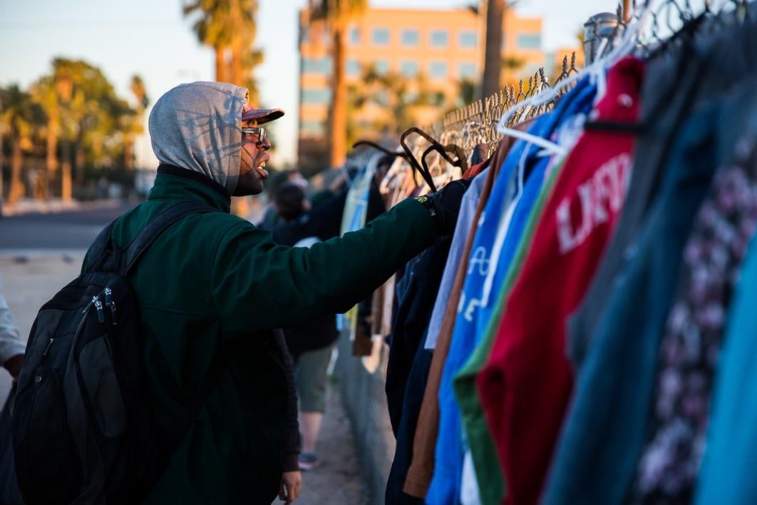 man sorting through clothing