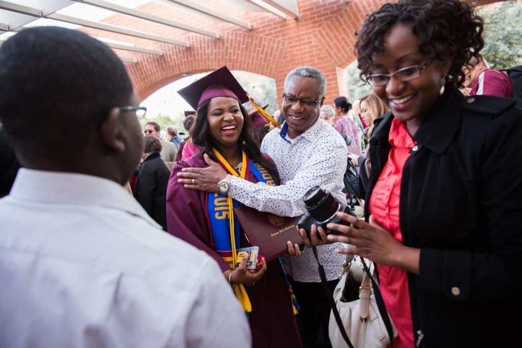 Graduate gets a hug from a man.