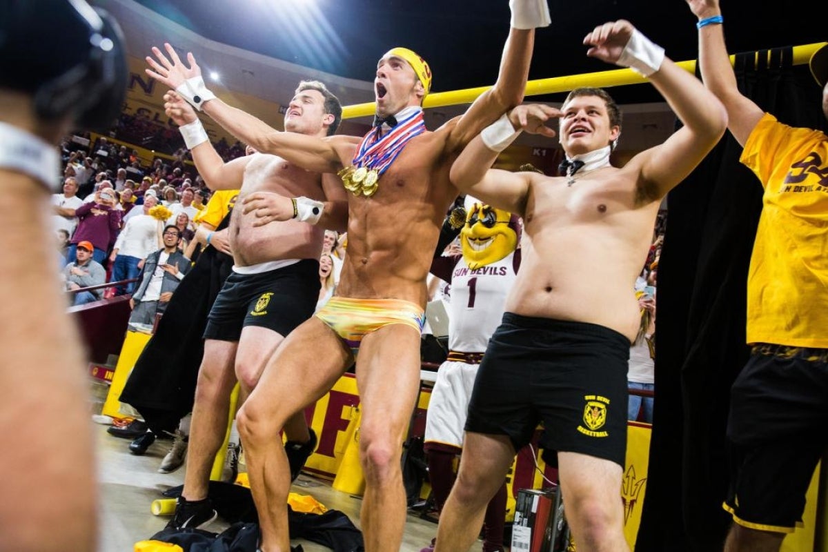 Michael Phelps and two ASU students jump out from the Curtain of Distraction