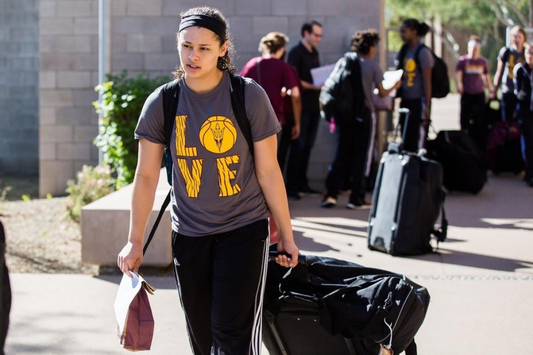 Woman walking with some luggage.