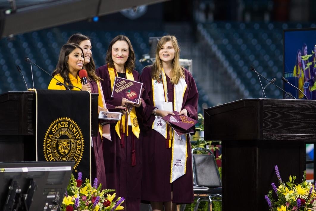 students holding mortarboards at commencement