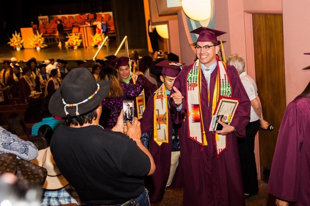 graduate posing for camera after leaving graduation