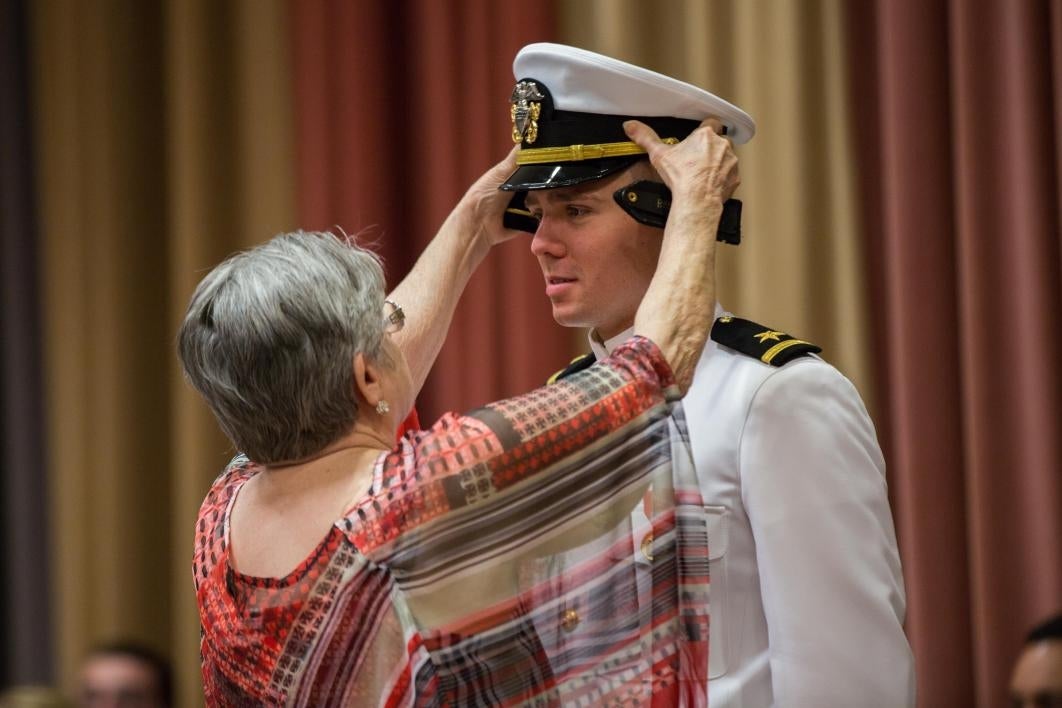 mom helping cadet adjust cap