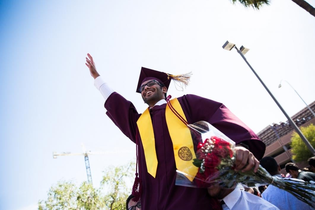 student being carried on friend's shoulders