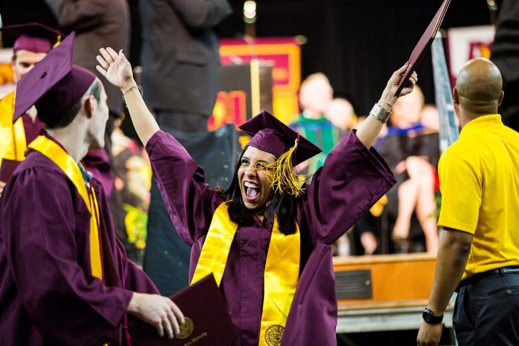 two graduates hugging