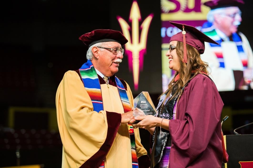 man handing graduate with award