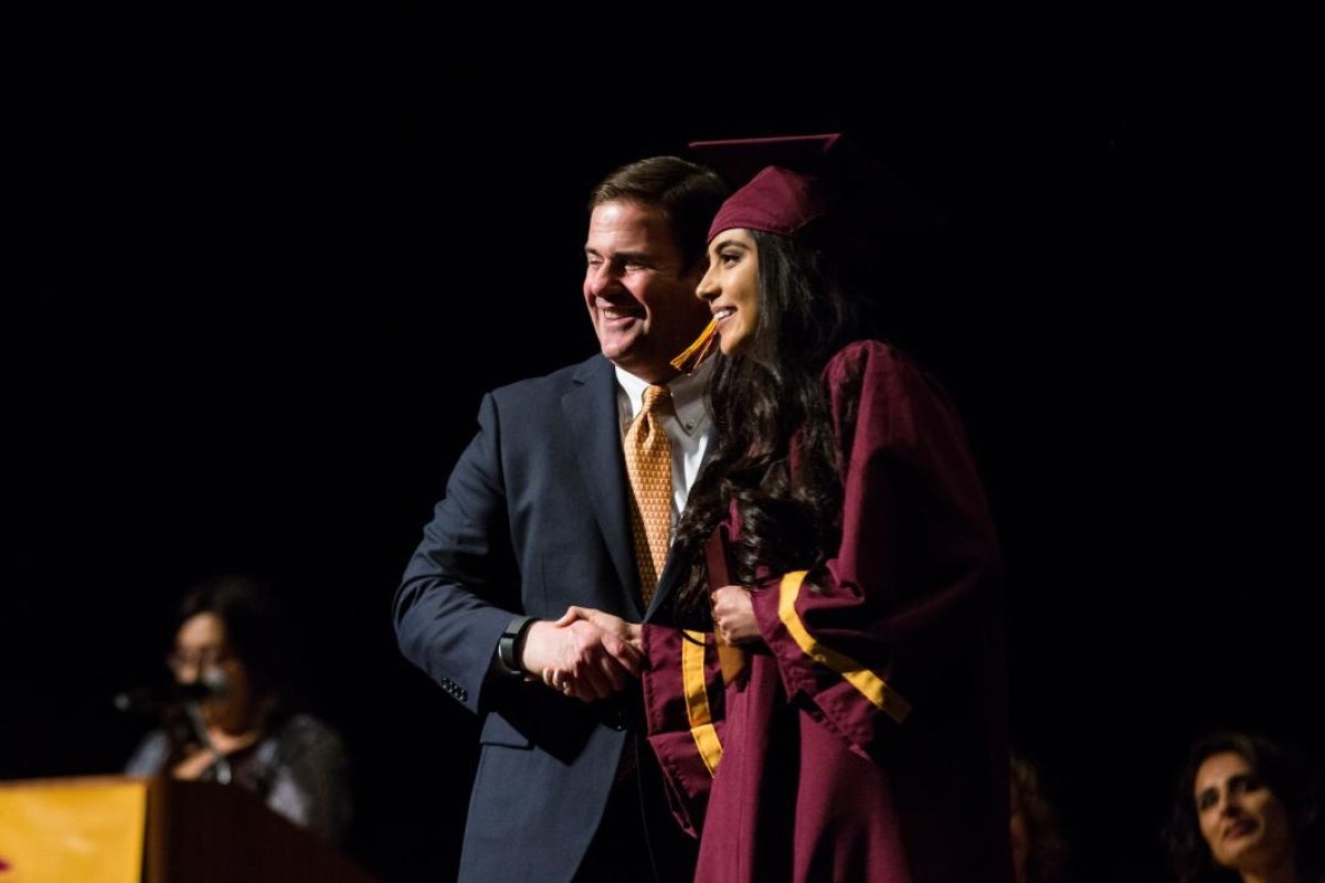 Arizona Gov. Doug Ducey poses with an ASU Prep graduate.