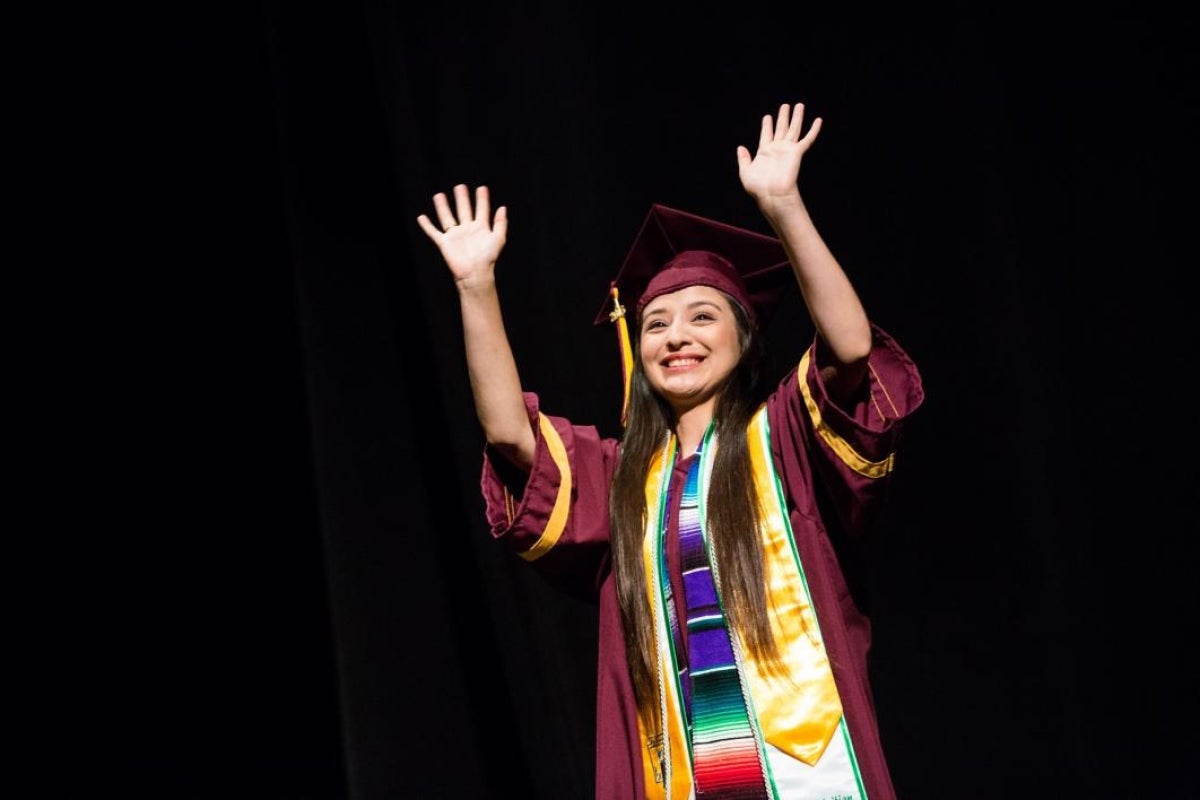 A student poses on stage during the ASU Prep-Phoenix commencement.