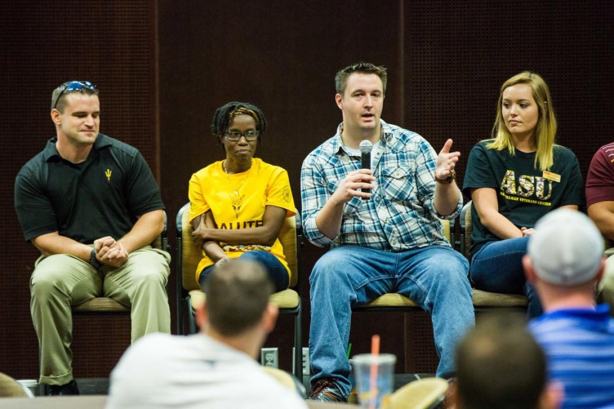 man on panel speaking into microphone