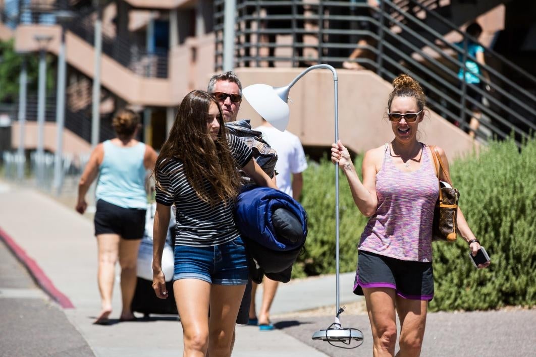 student and mom carrying items to the dorm room