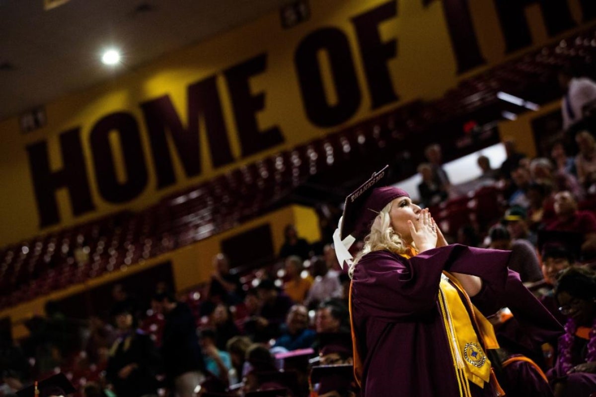 student blowing kisses at graduation