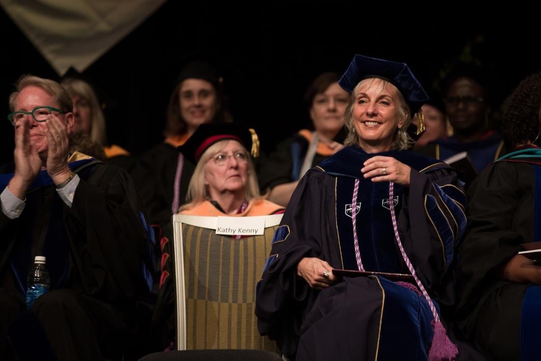 woman at graduation listening to speech