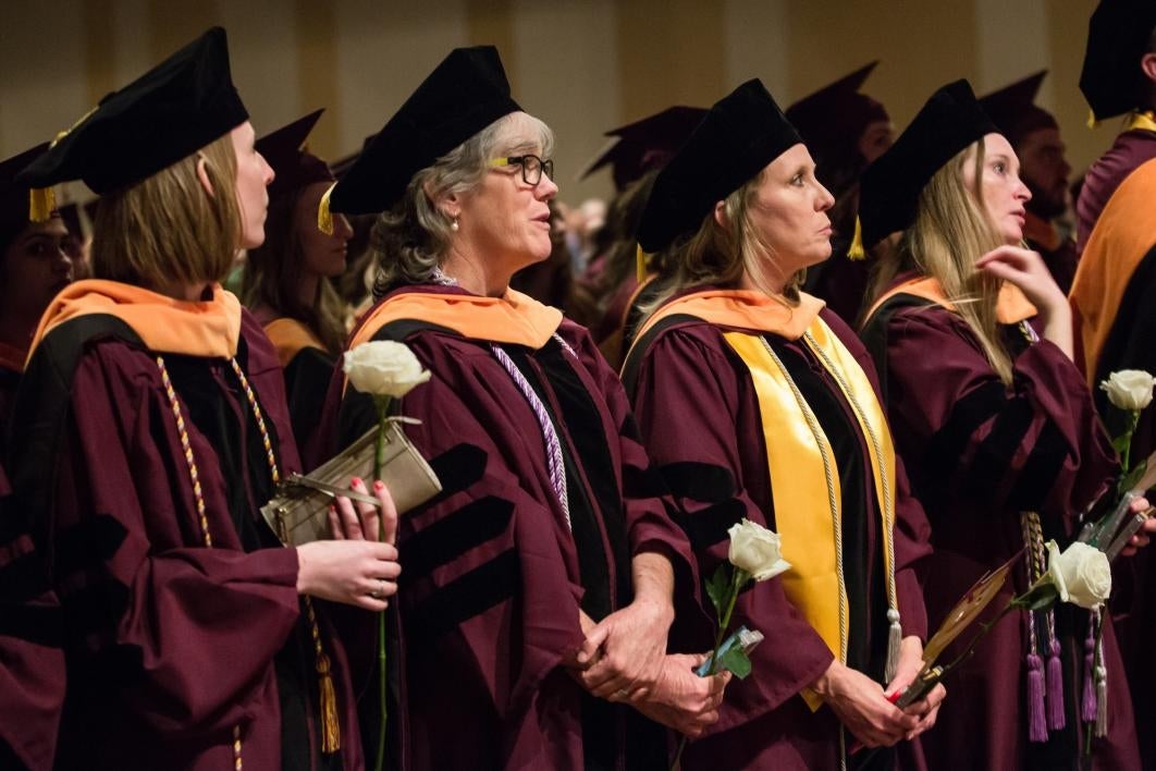 graduates holding roses