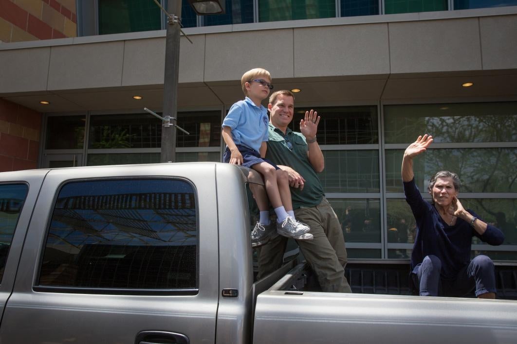 family waiting in back of pickup truck