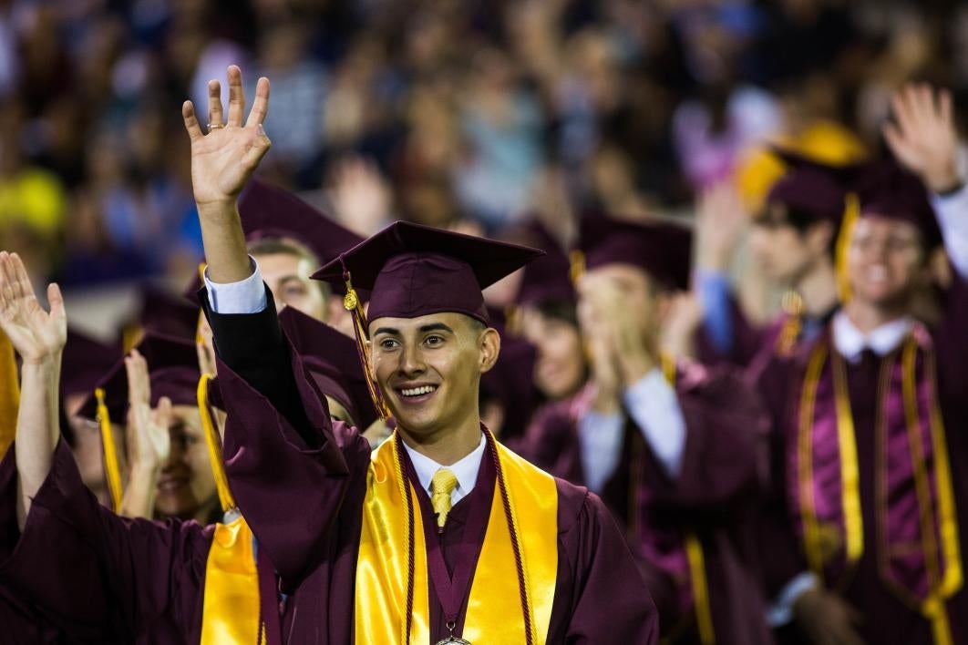 graduates waving