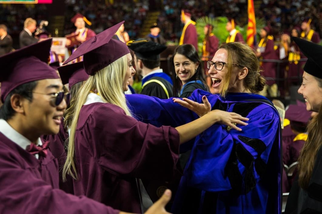 graduate getting hug from professor