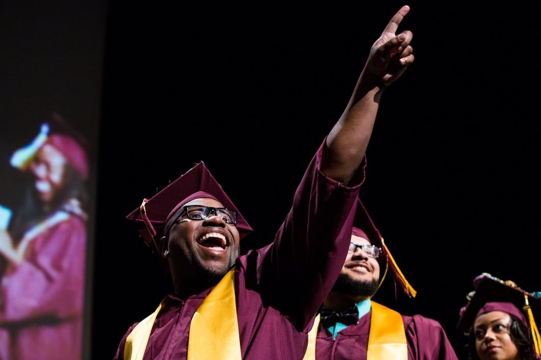 graduate pointing to family