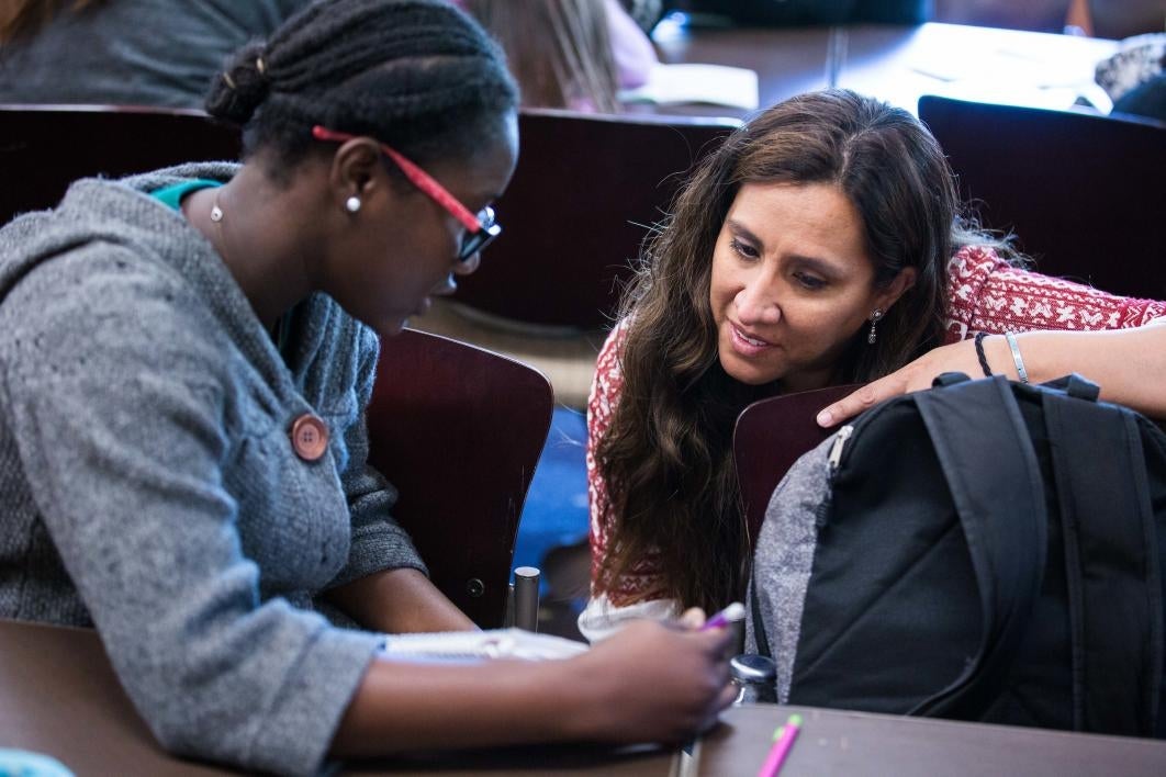 woman helping young girl write