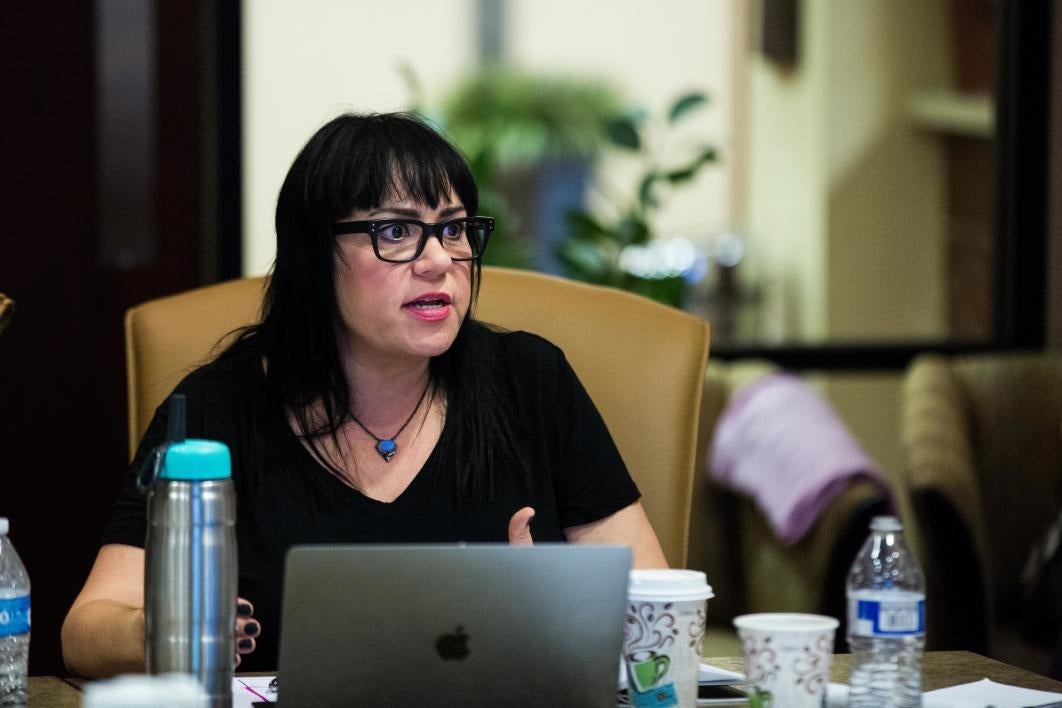 A woman sits at a conference table