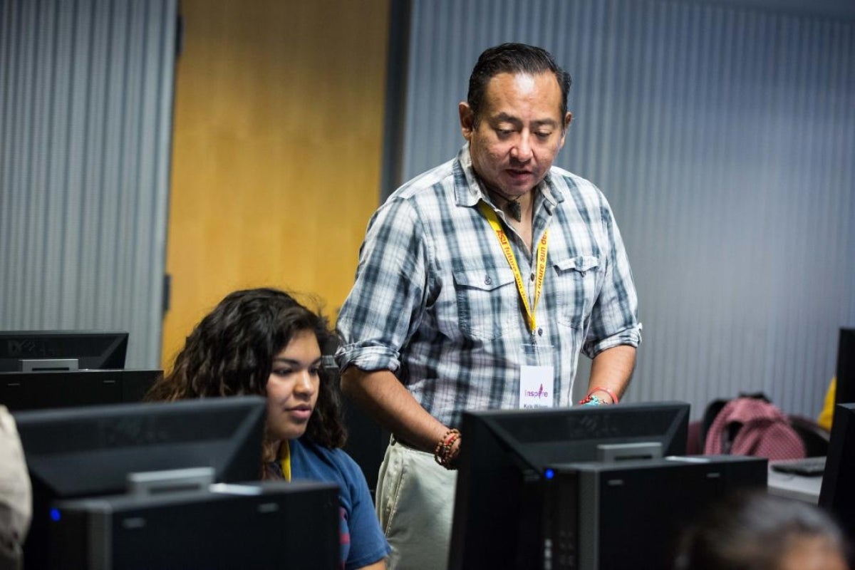 Indigenous Rhetoric coordinator and mentor Kyle Wilson works with high school student Alianna Pinon