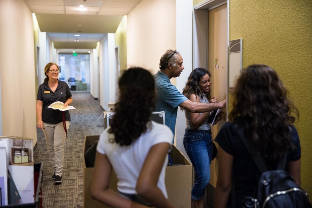 A family helps a student move into the dorm