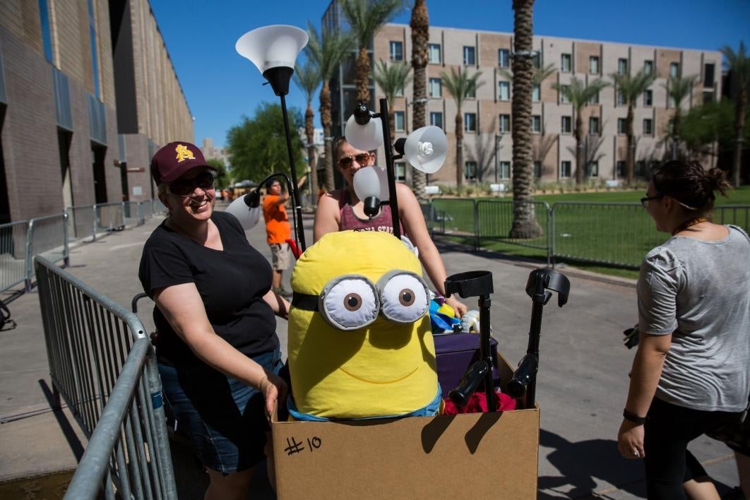 A student and her family unload her belongings at move-in