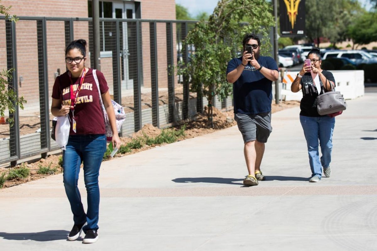 Parents take pictures of their daughter moving into college