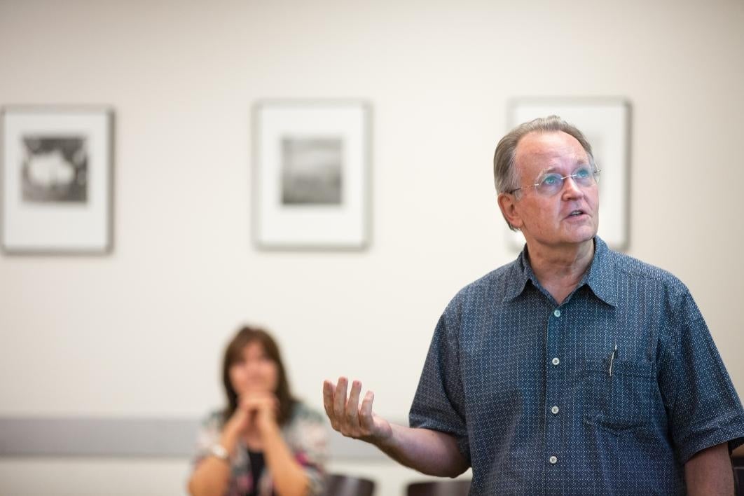 man giving lecture with woman in background