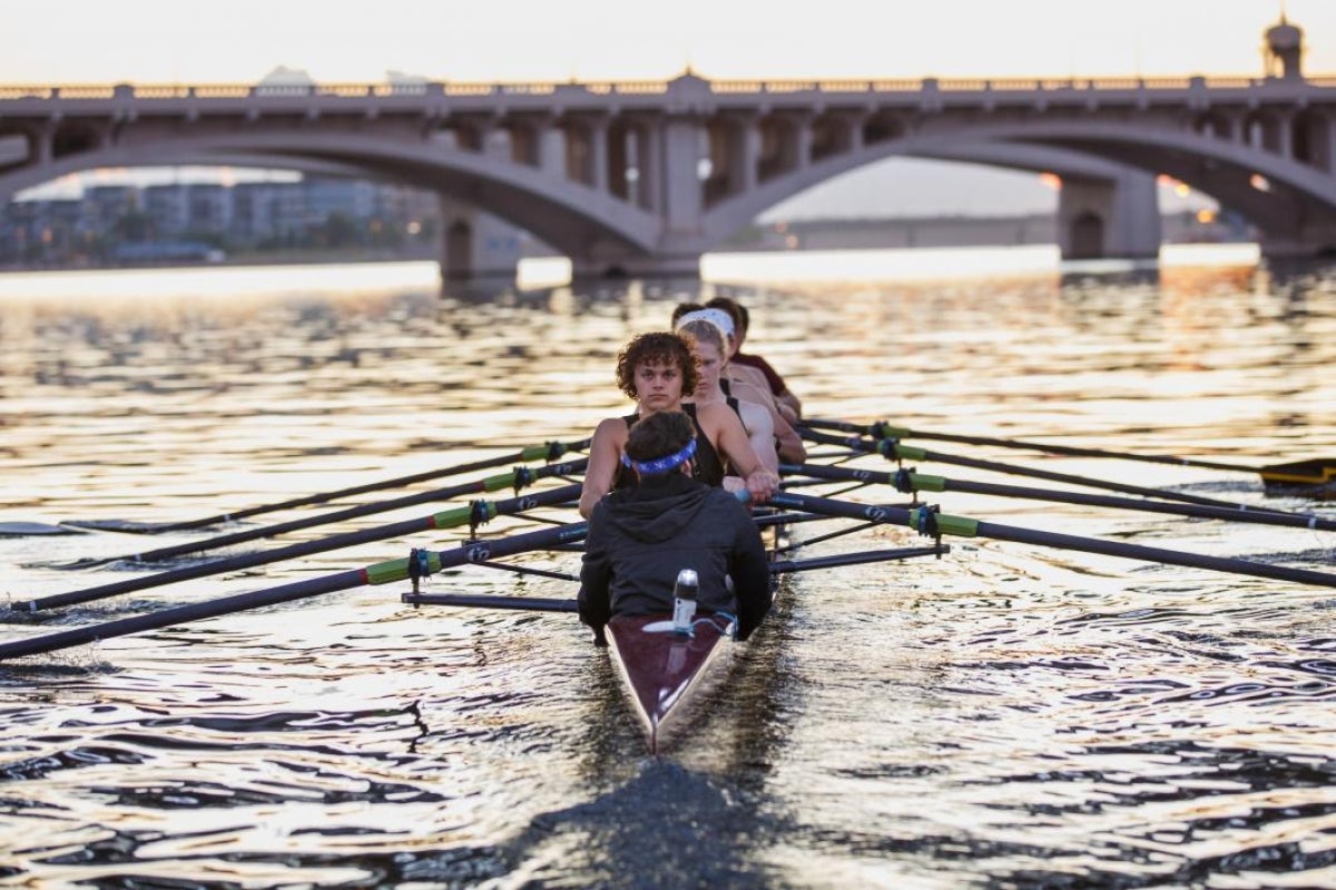 men's rowing team on lake