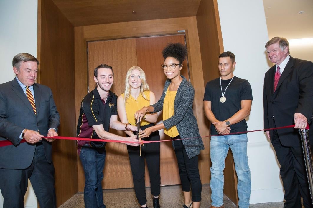 people cutting ceremonial ribbon